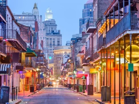 Bourbon St, New Orleans, Louisiana, USA cityscape of bars and restaurants at twilight