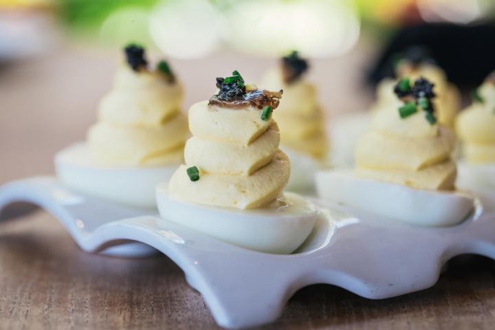 Ocean Prime's white truffle deviled eggs on a wooden table