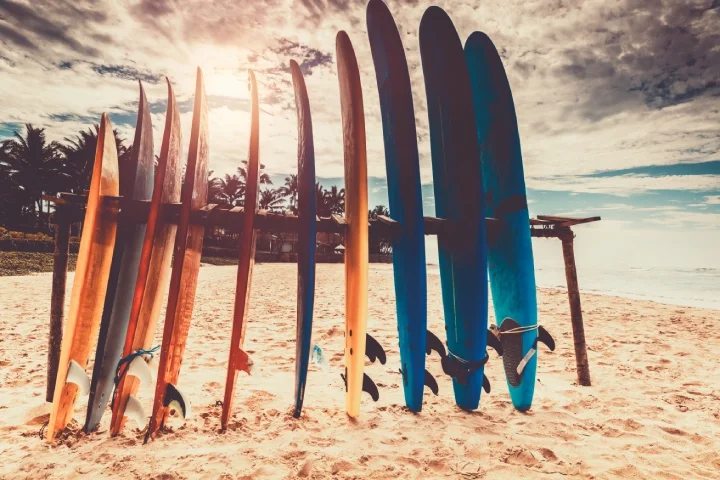 Surf boards on a sandy beach at sunset, after a day surfing