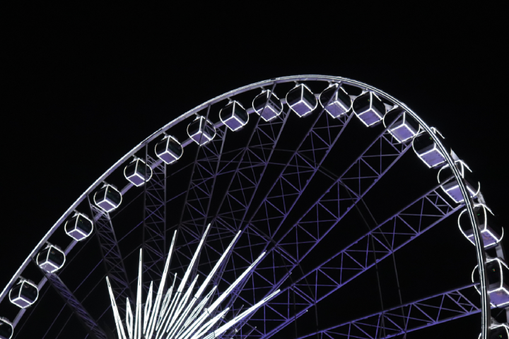 Coachella Festival's iconic ferris wheel glowing in the dark in a summer's night
