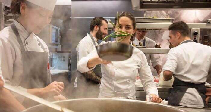 Elena from Arzak cooking in busy kitchen