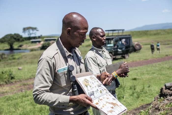 Guide shows children a book with pictures of animals