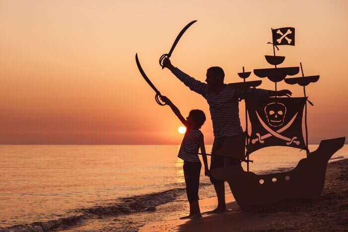 Father and Son pretend to be pirates on beach at sunset - Family Vacation