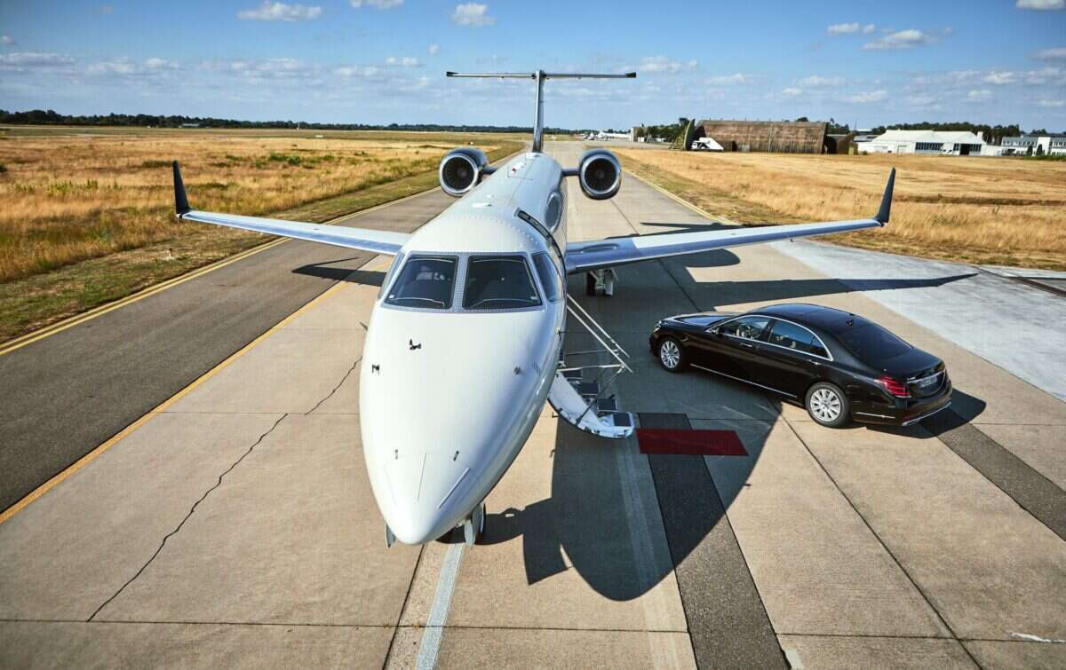 Air Partner private jet on runway with car