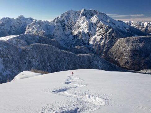 person skiing through mountains at alpine ski resort