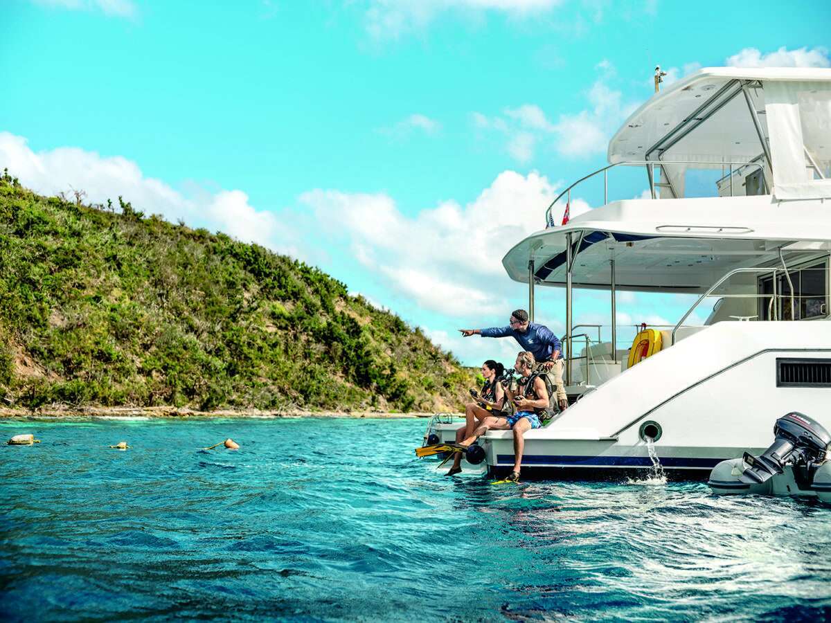 Family putting on scuba gear on a boat in the British Virgin Islands