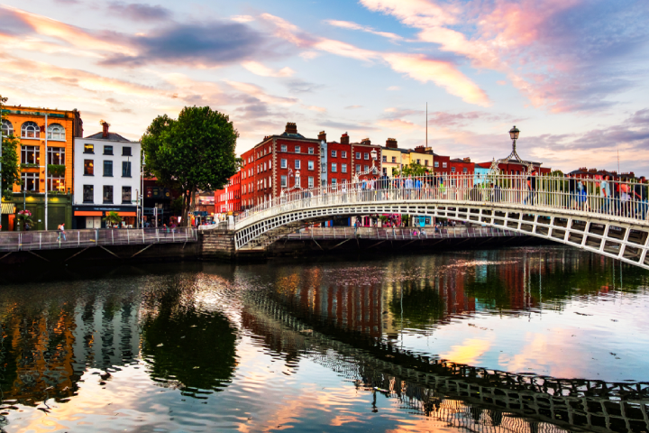 Ha Penny's bridge in Dublin, Ireland, at sunset surrounded by the colourful buildings of the capital