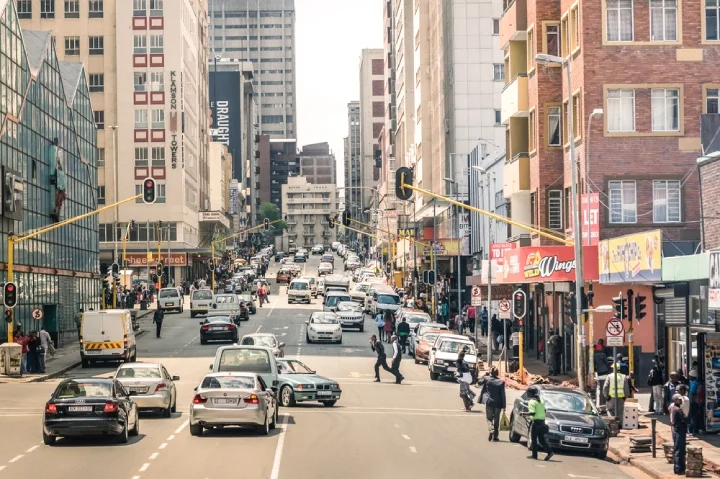 Rush hour and traffic jam on Von Wiellig Street at the crossroad with Commissioner St in the crowded and modern multiracial metropolis of Johannesburg in South Africa.