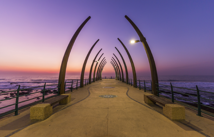 Umhlanga harbor in Durban, South Africa, with its peculiar architecture illuminated by a purple sky at sunset