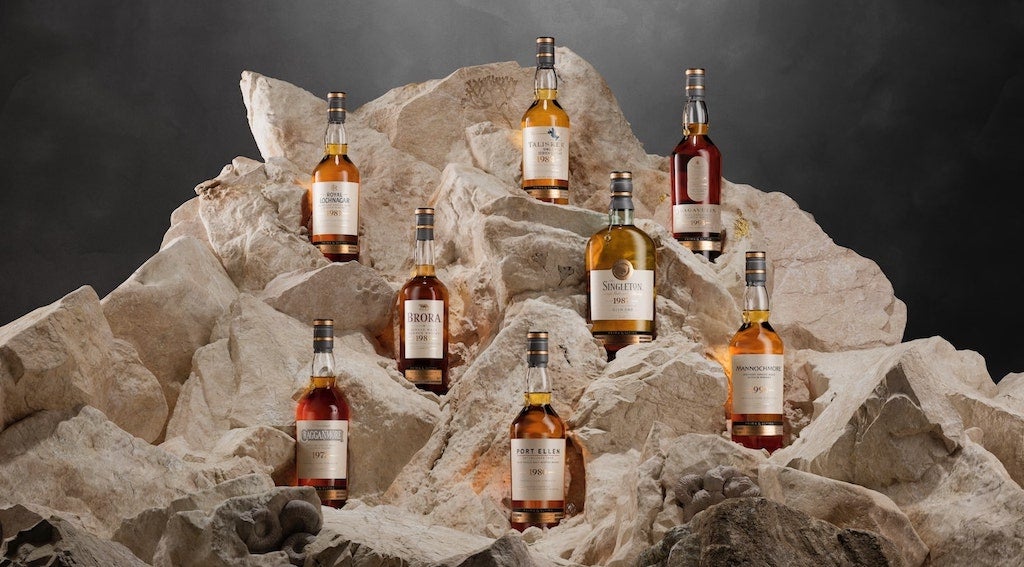 Eight bottles sitting on a rock
