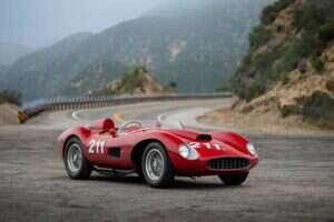 Image showing the 1957 Ferrari 625 TRC Spider against a mountain backdrop on the road.